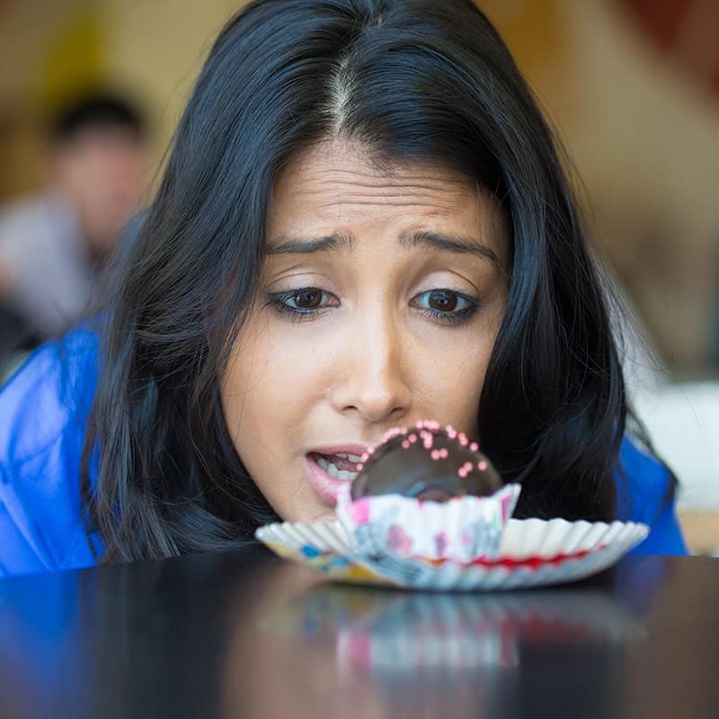 image of a woman staring longingly at a cupcake